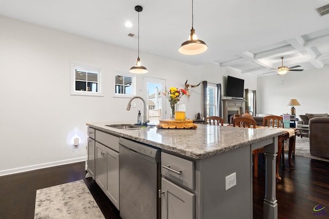 kitchen featuring pendant lighting, sink, dishwasher, a kitchen breakfast bar, and an island with sink