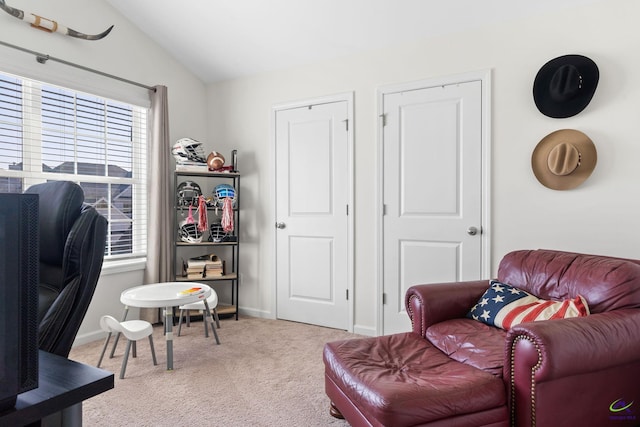 living area with light colored carpet and vaulted ceiling