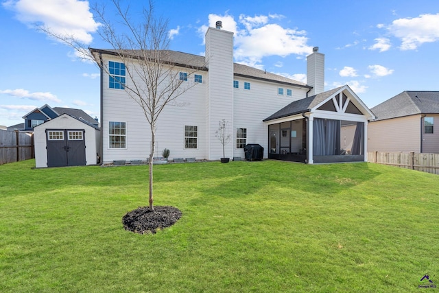 back of house with a storage shed, a lawn, and a sunroom