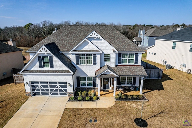 craftsman inspired home featuring cooling unit, a porch, a garage, and a front lawn