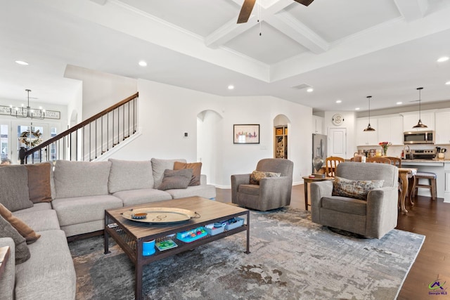 living room featuring crown molding, beam ceiling, coffered ceiling, dark hardwood / wood-style flooring, and ceiling fan with notable chandelier