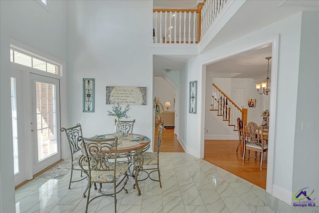 dining area featuring a chandelier and a high ceiling