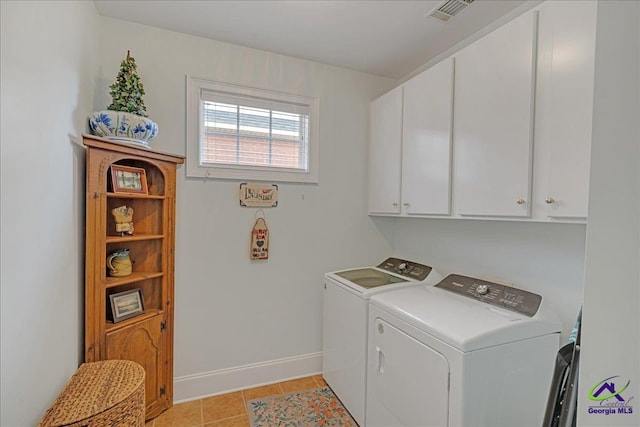 clothes washing area with cabinets, separate washer and dryer, and light tile patterned floors