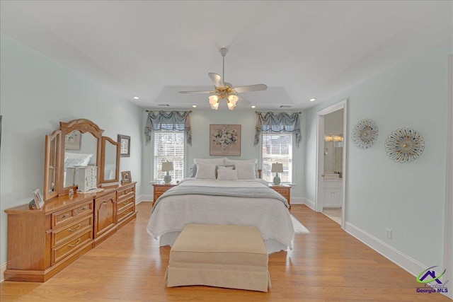 bedroom with ceiling fan, connected bathroom, and light hardwood / wood-style flooring