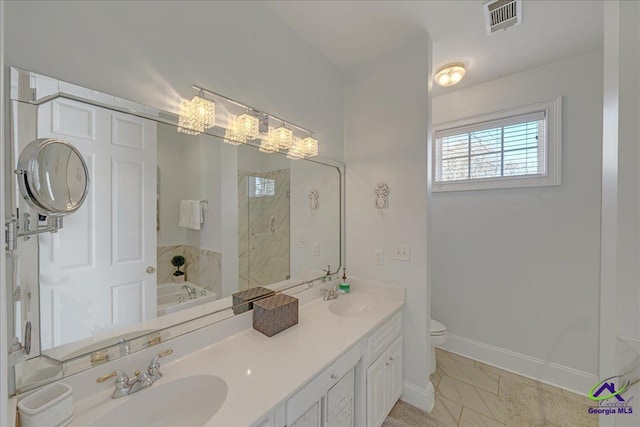 bathroom with vanity, a tub, and toilet