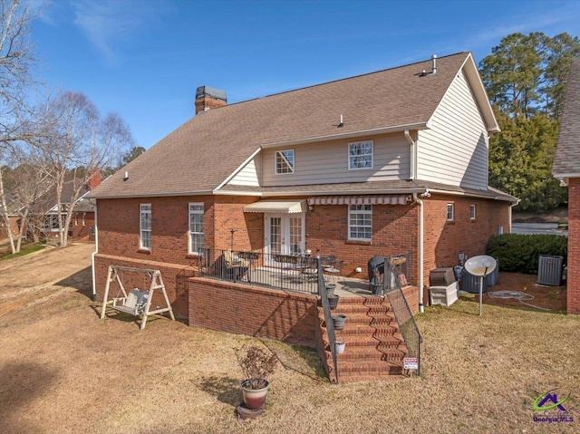 rear view of property featuring a patio, central air condition unit, and a lawn