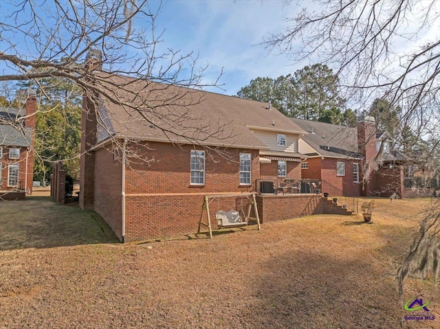 rear view of property featuring a lawn