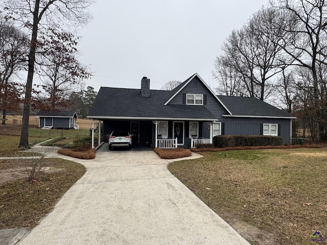 view of front of house featuring a carport, a storage unit, covered porch, and a front lawn