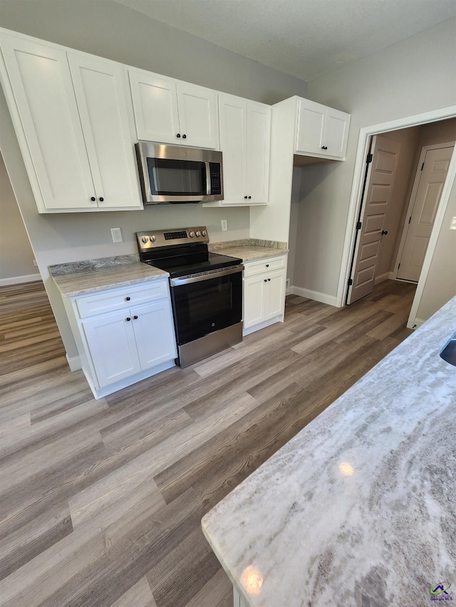 111 Silver Maple, Byron, GA 31008 - kitchen with white cabinets, light wood finished floors, appliances with stainless steel finishes, and baseboards