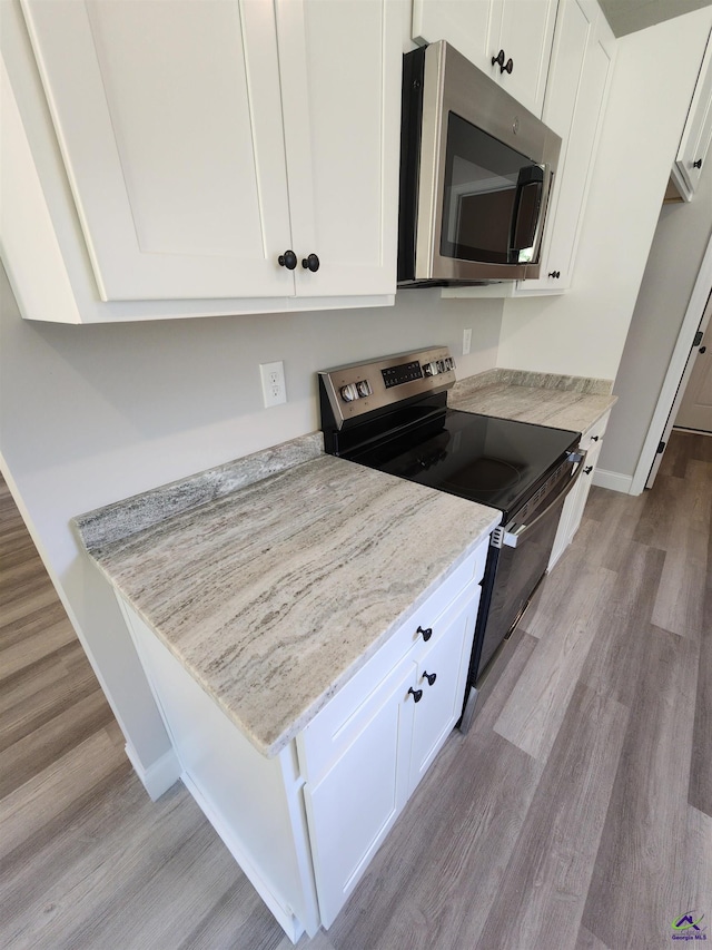 111 Silver Maple, Byron, GA 31008 - kitchen with wood finished floors, white cabinets, baseboards, light stone countertops, and appliances with stainless steel finishes