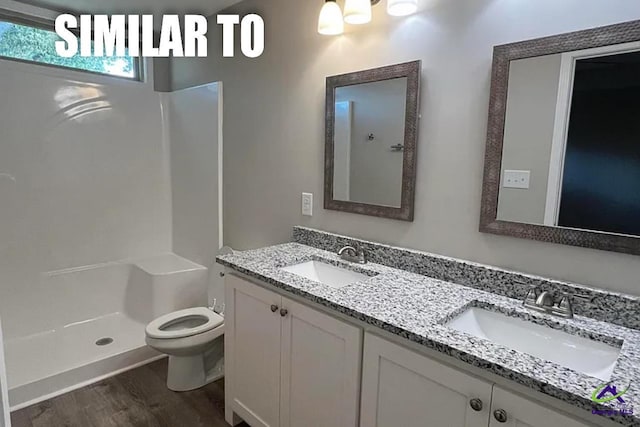 bathroom with vanity, hardwood / wood-style flooring, toilet, and a shower