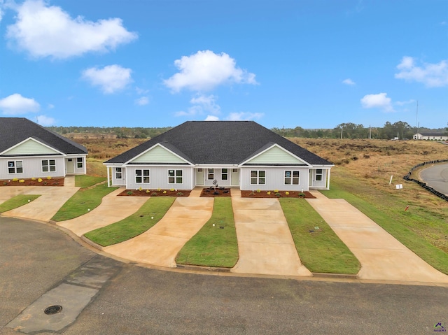 ranch-style home featuring covered porch and a front lawn