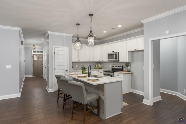 kitchen with sink, a kitchen island with sink, white cabinetry, stainless steel appliances, and a kitchen breakfast bar