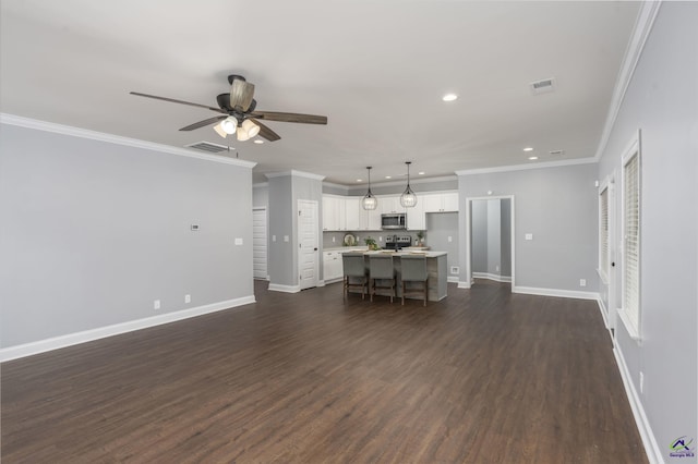 unfurnished living room featuring dark hardwood / wood-style flooring, ornamental molding, and ceiling fan