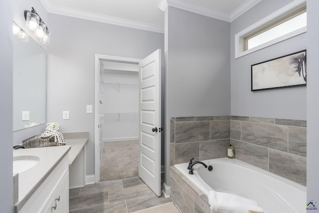 bathroom with vanity, crown molding, and tiled bath