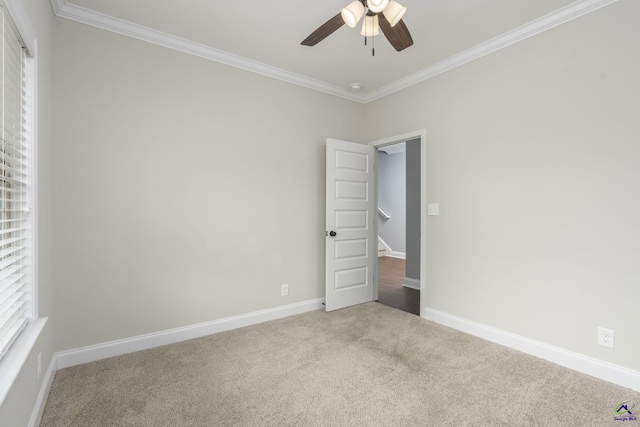 unfurnished room featuring crown molding, light colored carpet, and ceiling fan