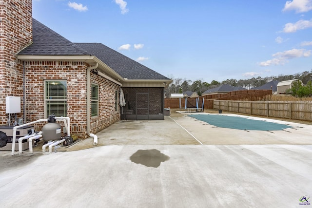 view of swimming pool featuring a sunroom and a patio area