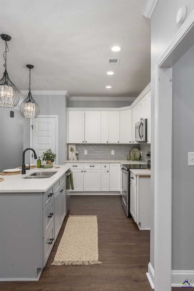 kitchen featuring white cabinetry, sink, stainless steel appliances, and hanging light fixtures