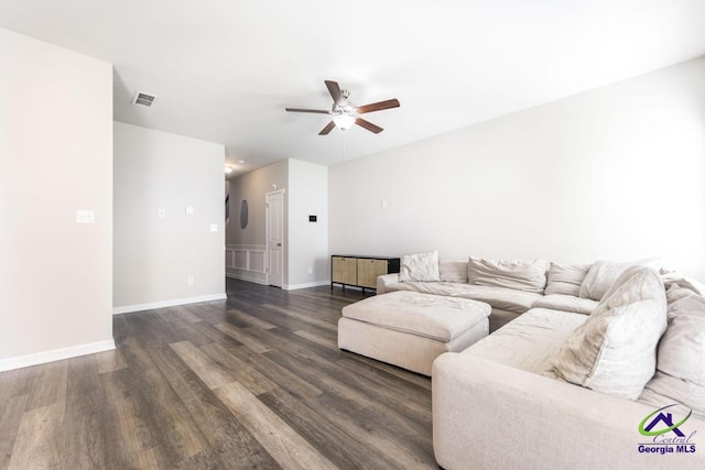 living room with ceiling fan and dark wood-type flooring