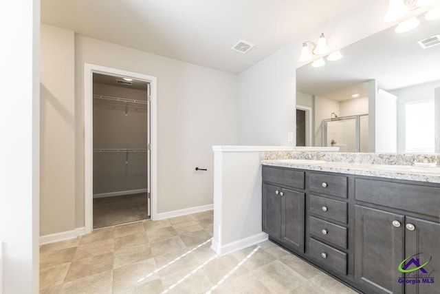 bathroom featuring vanity and a shower with shower door