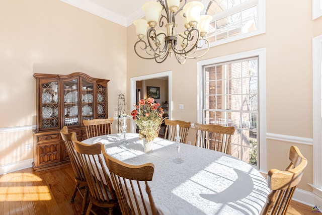 dining room with an inviting chandelier, hardwood / wood-style flooring, ornamental molding, and a healthy amount of sunlight