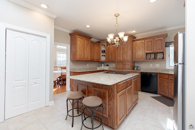 kitchen featuring a center island, light stone counters, ornamental molding, black appliances, and a kitchen bar