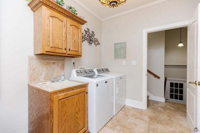 laundry area with cabinets, ornamental molding, sink, and independent washer and dryer