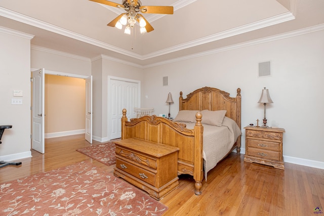 bedroom with wood-type flooring, ornamental molding, ceiling fan, and a closet