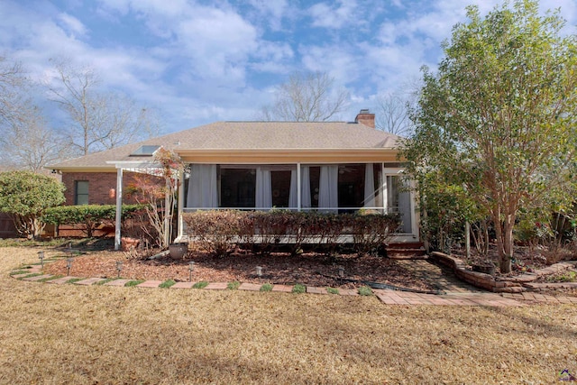 exterior space with a sunroom and a front lawn