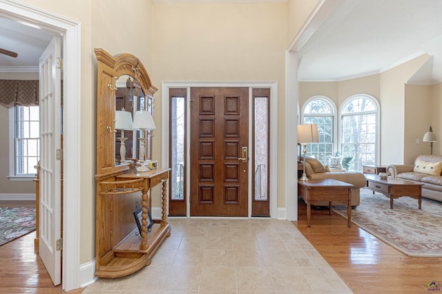 entrance foyer with light hardwood / wood-style flooring and ornamental molding