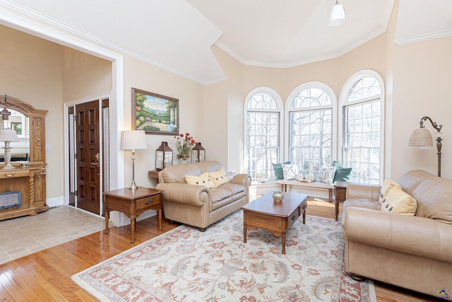 living room featuring lofted ceiling, ornamental molding, and light wood-type flooring