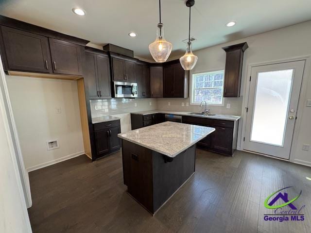 kitchen featuring sink, a center island, hanging light fixtures, dark hardwood / wood-style flooring, and decorative backsplash