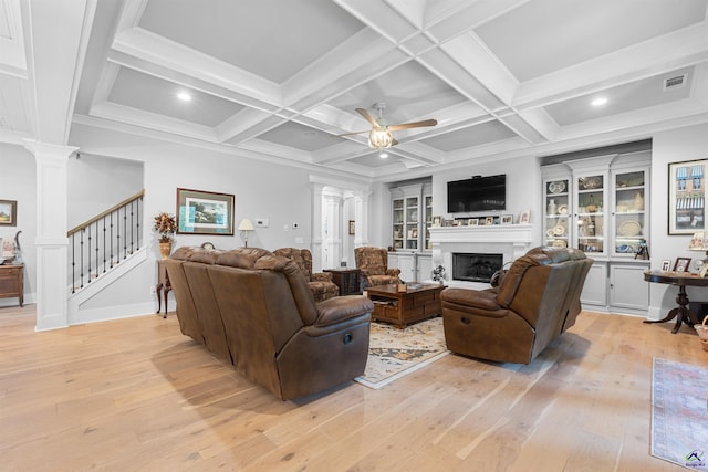 living room featuring ceiling fan, ornate columns, coffered ceiling, beamed ceiling, and light wood-type flooring