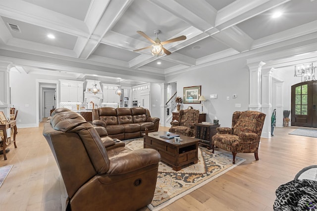 living room featuring decorative columns, light wood-type flooring, and beamed ceiling