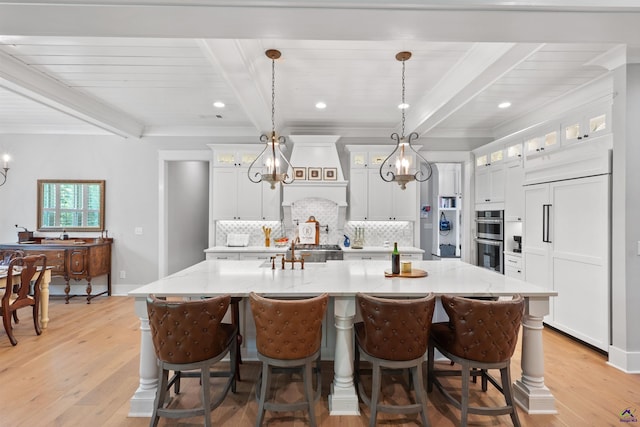 kitchen featuring a spacious island, white cabinets, and pendant lighting