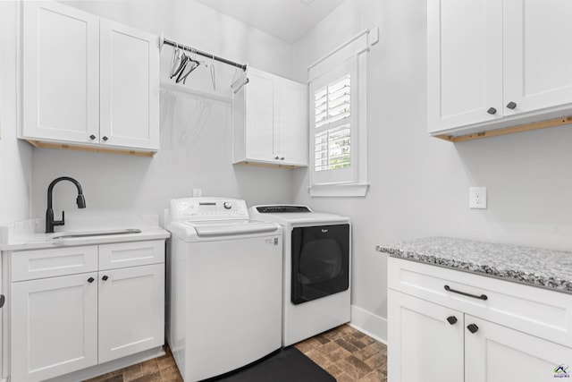 washroom featuring cabinets, sink, and washing machine and clothes dryer