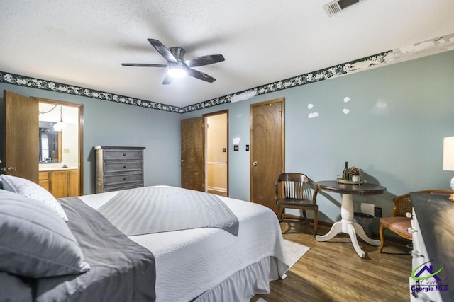 bedroom featuring hardwood / wood-style flooring, ceiling fan, and connected bathroom