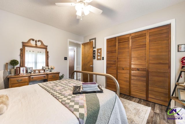 bedroom with dark hardwood / wood-style flooring, a textured ceiling, a closet, and ceiling fan