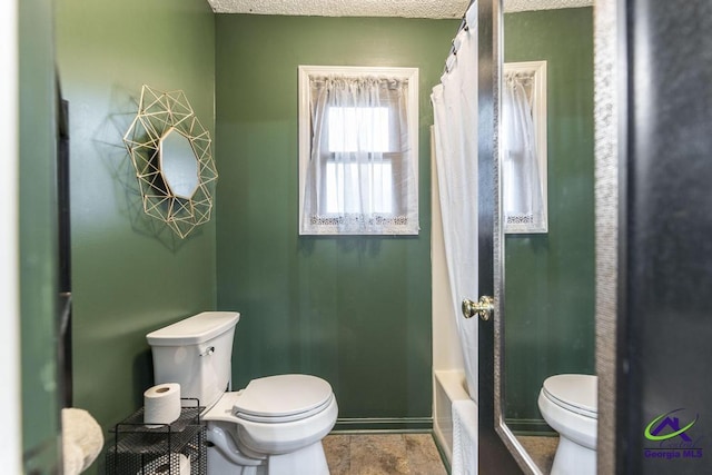 bathroom with shower / bath combination with curtain and toilet