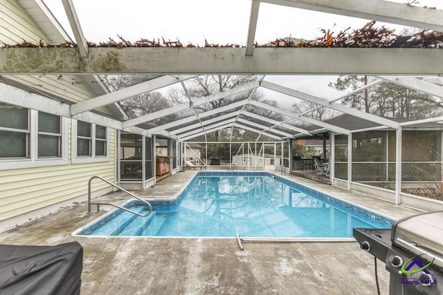 view of swimming pool with a shed, a patio area, and glass enclosure