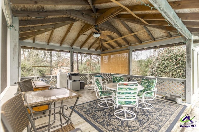 sunroom / solarium with ceiling fan, lofted ceiling, and a wealth of natural light