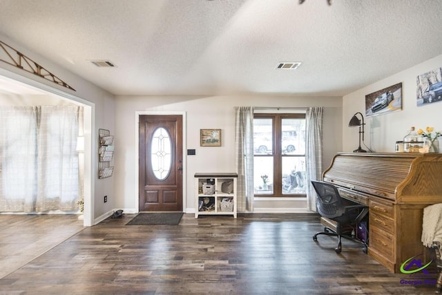 foyer entrance featuring dark wood-type flooring and a textured ceiling