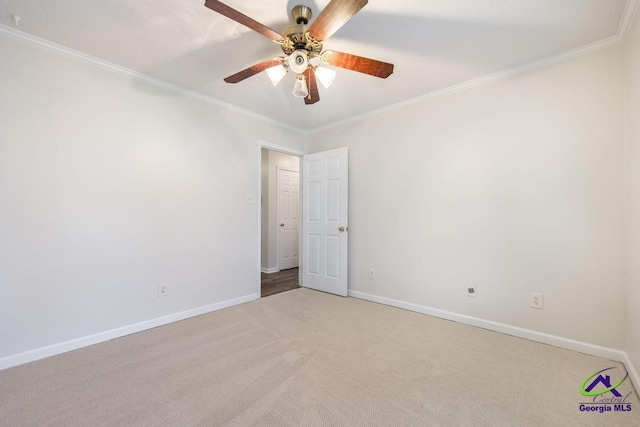 carpeted spare room featuring crown molding and ceiling fan