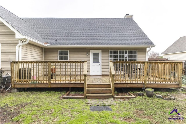 back of house with a wooden deck and a lawn