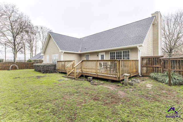 rear view of house featuring a yard and a deck