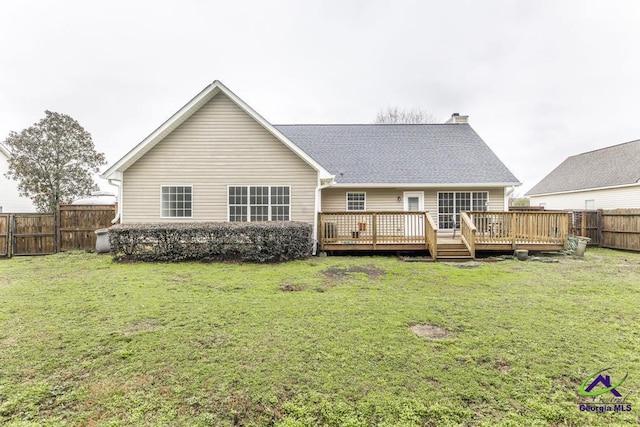 back of property with a wooden deck and a yard