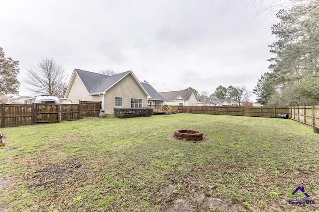 view of yard with a wooden deck and an outdoor fire pit