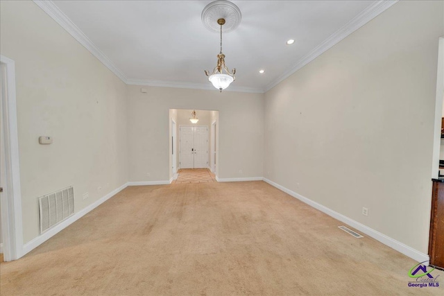 empty room featuring crown molding and light carpet