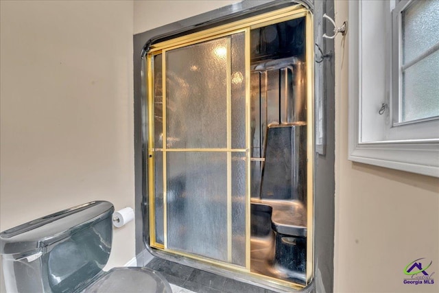 bathroom with an enclosed shower and toilet