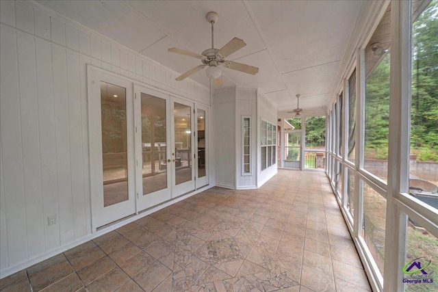 unfurnished sunroom with ceiling fan